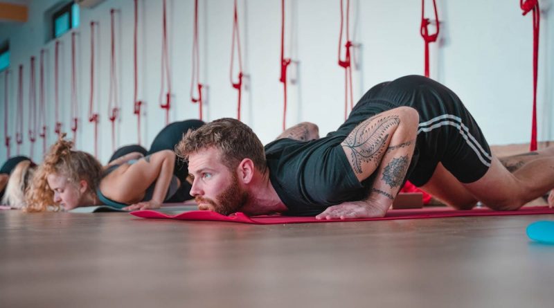 Adults participating in a yoga class, focusing on floor exercises in Rishikesh, India.